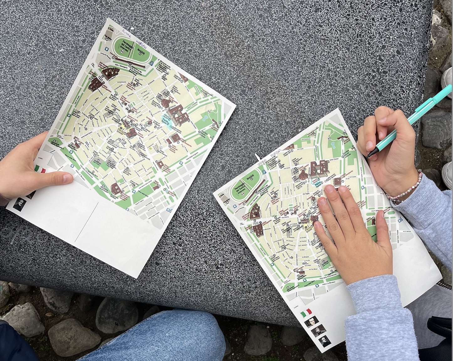 Mani di bambini che tengono due mappe della città di Modena con i luoghi del Risorgimento.