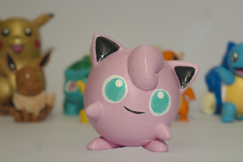 In primo piano c'è un Pokemon Jigglypuff rosa,  riprodotto con la stampa 3d.