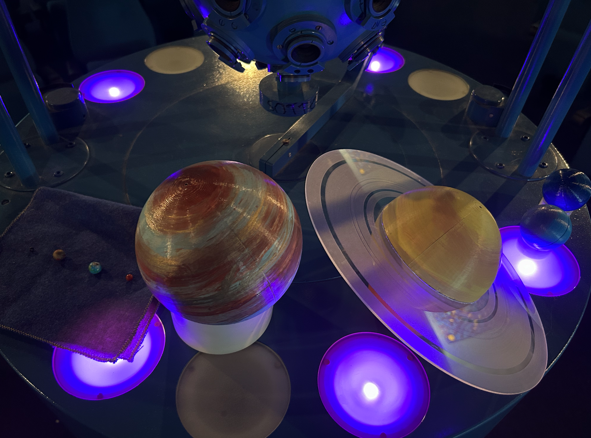 Consolle del Planetario con strumenti di proiezione sulla cupola, luci viola e sagome di pianeti